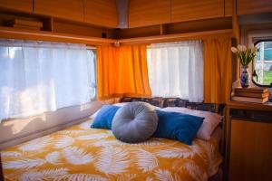 a bed in a room with two windows at Caravan near the sea 4 in Ugljan