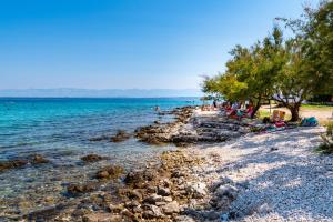 a group of people sitting on a beach near the water at Caravan near the sea 4 in Ugljan