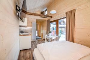 a bedroom with a white bed and a kitchen at Apartament & Domek u Gabrysi in Białka Tatrzanska