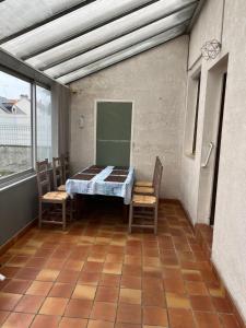 a room with a table and chairs on a balcony at Nantes Maison entière 5 lits La Coulée in Nantes
