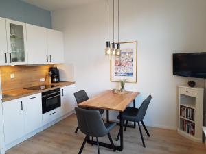 a kitchen and dining room with a wooden table and chairs at Ferienwohnung Heimathafen in Borkum