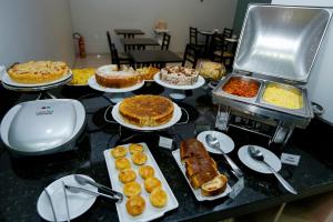 a table with plates of food on it at Hotel Mandino in Lucas do Rio Verde