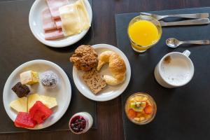 a table with two plates of pastries and orange juice at Ritz Hotel Mendoza in Mendoza
