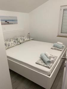 a bed in a bedroom with two towels on it at Apartments Štica- Pelješac in Janjina