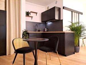 een kleine keuken met een tafel en 2 stoelen bij Appartement Cosy Hyper Centre in Nantes