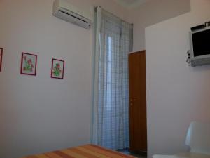 a bedroom with a bed and a tv and a window at Amarfia Bed & Breakfast - Your Home In Salerno in Salerno