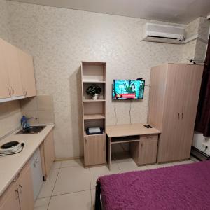 a small kitchen with a desk and a tv on the wall at Квартира- студия возле метро Академика Павлова in Kharkiv