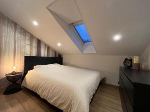ein Schlafzimmer mit einem weißen Bett und einem Fenster in der Unterkunft Chalet Mésange in Érezée