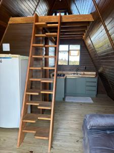 a wooden staircase in a tiny house at Cabana Aroma do Mar in Jaguaruna +2 photos