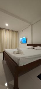 una camera da letto con un letto grande con una TV a parete di VThree Family House a Matara