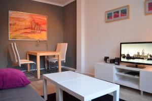 ein Wohnzimmer mit einem Tisch und einem TV in der Unterkunft F1 - Kunst und Design Dresden in Dresden