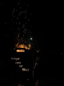 a fire in a container with a sign in the dark at Montecielo in San Antonio de Arredondo