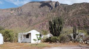 a small white building in front of a mountain at Refugio Shangrila in Jordán