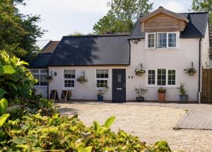 a white house with a black roof at Granary Villa in Kidderminster