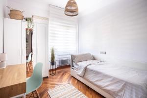 Un dormitorio blanco con una cama y una mesa. en El Ñeru del Marqués - VUT5160AS, en Gijón