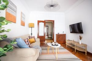Una sala de estar con un sofá y un televisor. en El Ñeru del Marqués - VUT5160AS, en Gijón