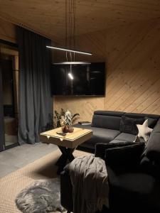 a living room with a couch and a table at Domek & Apartament Góralski z Jacuzzi Kościelisko in Kościelisko