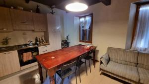 a kitchen with a wooden table and a couch at Maria's home in Bardi