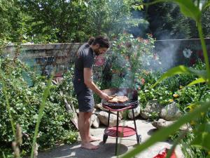 Ein Mann, der Essen auf einem Grill im Garten kocht in der Unterkunft Casa Sauschneider in Sankt Ruprecht ob Murau