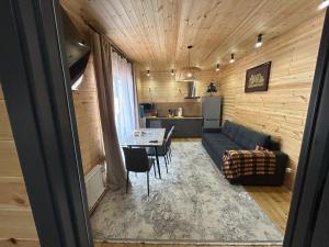 a living room with a couch and a table and a kitchen at Bermet guest house in Karakol