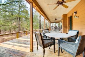 a porch with a table and chairs and a ceiling fan at Norfork Lake Access Cabin with Deck and Water View! in Elizabeth