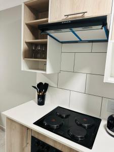 a black stove top in a white kitchen at Homely Stay 2 in Kempton Park +10 photos