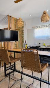 cocina con mesa y 2 sillas y TV en Departamento con Pileta camino a Cañon del Atuel San Isidro Pleno, en San Rafael