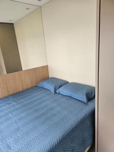 フロリアノポリスにあるCasa Vogue - Novo Campecheの青い枕2つが備わるベッド1台