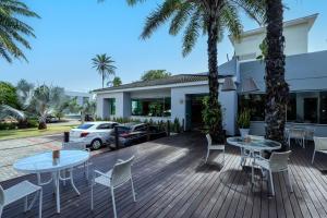 Busca-VidaにあるBahia Plaza Hotelのヤシの木が植えられたデッキ(テーブル、椅子付)