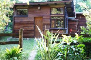 a wooden house with a fence in front of it at Refugio del Monte in Veronica