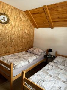Dos camas en una habitación con techos de madera. en -Moon-, en Kupres