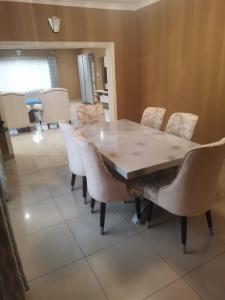 a dining room with a wooden table and chairs at Tina's Place in Lilongwe