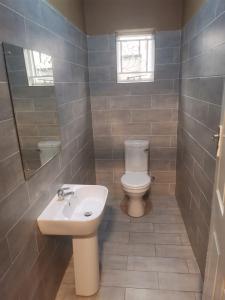 a bathroom with a toilet and a sink at Tina's Place in Lilongwe +9 photos