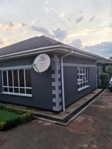 a house with a satellite dish on the side of it at Tina's Place in Lilongwe