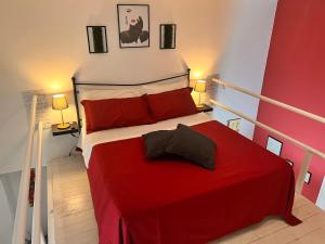 ein Schlafzimmer mit einem roten Bett mit zwei Kissen in der Unterkunft Stupendo bilocale con soppalco vicino alla Reggia di Caserta in Caserta