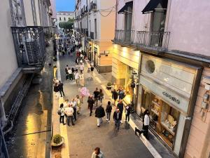 Eine Gruppe von Menschen, die eine Straße entlang gehen in der Unterkunft Stupendo bilocale con soppalco vicino alla Reggia di Caserta in Caserta