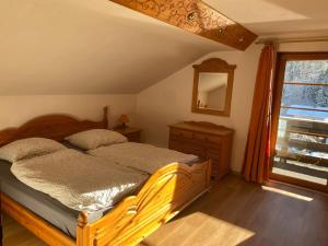 a bedroom with a wooden bed and a window at Zugspitzhaus Monika in Lermoos