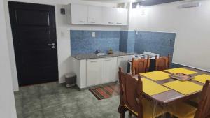 a kitchen with a table and a black door at hena apart 2 in Esquel