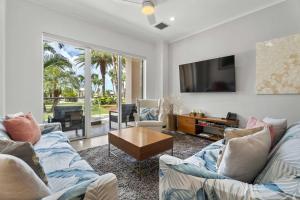 a living room with a couch and a tv at Eagle Beach - Diamond Garden 2BR condo - LV104 in Palm-Eagle Beach