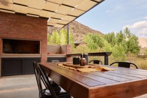 a wooden table and chairs on a patio with a view at Viví Potrerillos in Potrerillos