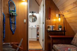 un corridoio di una casa con lavandino e specchio di Tiny Timber a Packwood