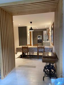 Chalet luxueux avec piscine intérieure في لابريس: مطبخ وغرفة طعام مع طاولة وغرفة طعام