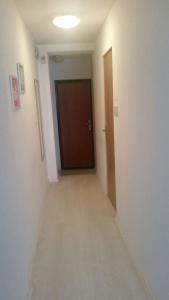 Un pasillo con una puerta en una habitación con un pasillo de longitud en Apartman ARNO, en Sarajevo