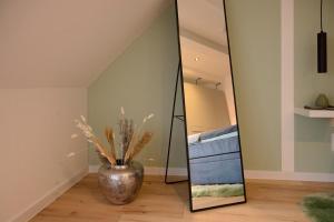 a large mirror in a room with a vase at Ferienwohnung Domschatz in Goslar