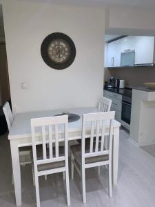cocina con mesa blanca y sillas blancas en Apartman ARNO, en Sarajevo