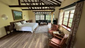a bedroom with a bed and a couch and chairs at Hotel Plazuela de San Agustín - PSA Hotel in Villa de Leyva +59 photos