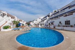a large swimming pool in a courtyard of a hotel at Sunset View Studio at Port Royale with heated pool and free Wi-Fi in Arona