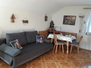 ein Wohnzimmer mit Sofa und Tisch in der Unterkunft Gästehaus Reisacher - Mehrbettzimmer in Peiting