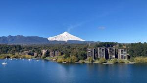 une montagne au fond d'un lac avec des bâtiments dans l'établissement Espectacular vista al lago y al volcán, à Pucón