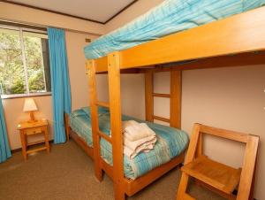 une chambre avec deux lits superposés et une lampe dans l'établissement Espectacular vista al lago y al volcán, à Pucón 10 autres photos